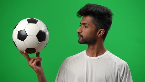 Middle Eastern Footballer Looking at Ball in Hand and Looking at Camera Smiling