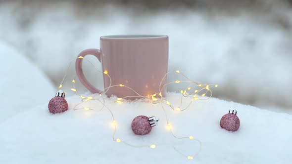 Cup of Hot Drink with Christmas Balls on Snow