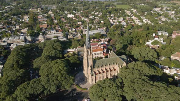 Aerial orbit shot of San Isidro Cathedral surrounded by residential neighborhood near Buenos Aires c