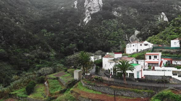 Aerial Shot. Highland Village in a Canyon Between Two Hills and Mountains. Low Storm Clouds. Palm