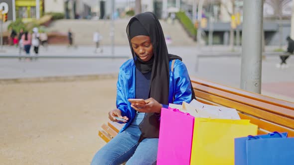 Muslim Woman Making Online Purchases on Street