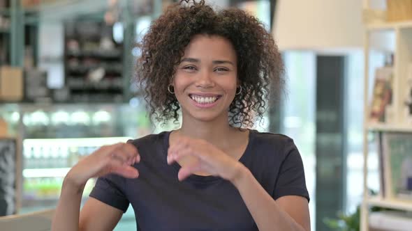 Portrait of Smiling African Woman Making Heart Shape