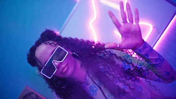 Beautiful Woman in Stylish Glasses Dancing in Neon Light