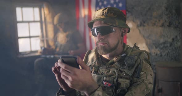 American Soldier Browsing Smartphone During War