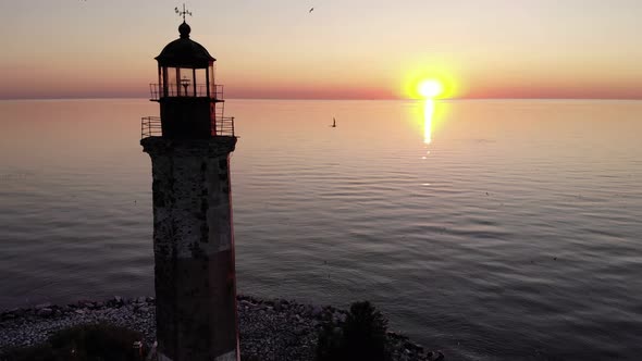 Aerial shot of Sukho lighthouse at sunset, bright sun shine low