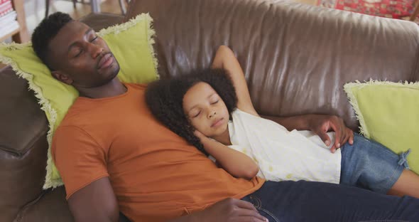 African american father and daughter sleeping in sofa