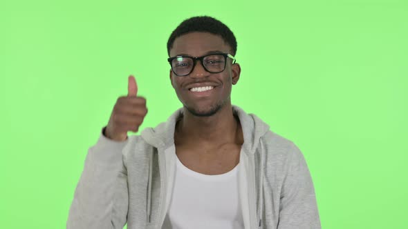 African Man Showing Thumbs Up Sign on Green Background