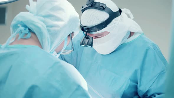 A Surgeon is Wearing a Headlight While Performing an Operation