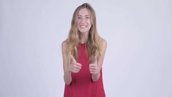 Happy Young Beautiful Blonde Woman Looking Excited and Giving Thumbs Up