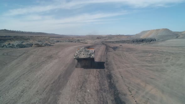 Drone Camera Follows a Dump Truck Loaded with Quarry Coal