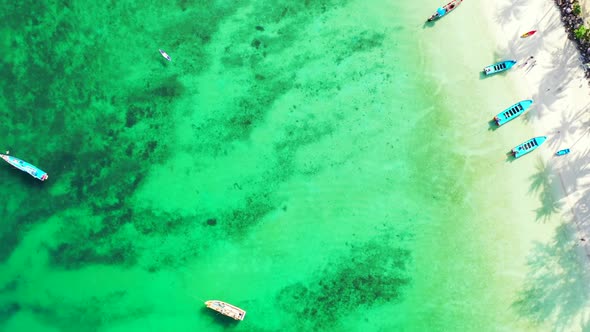 Aerial top down abstract of tropical resort beach lifestyle by blue water with white sandy backgroun