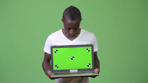 Young African Man Showing Laptop