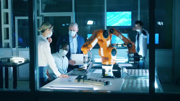 Engineers in Masks Working at Robotics Development Laboratory