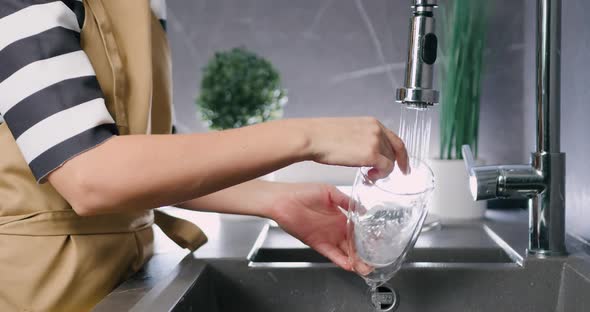 Close up of Caucasian Female Hands Washing Glass Dishes Under Water Jet at Modern Home Kitchen