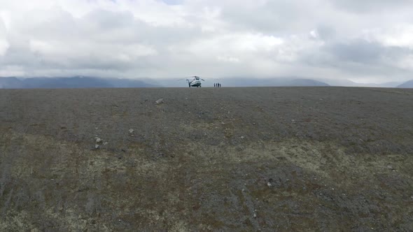 Aerial view of a helicopter and a group of hikers on a mountain top