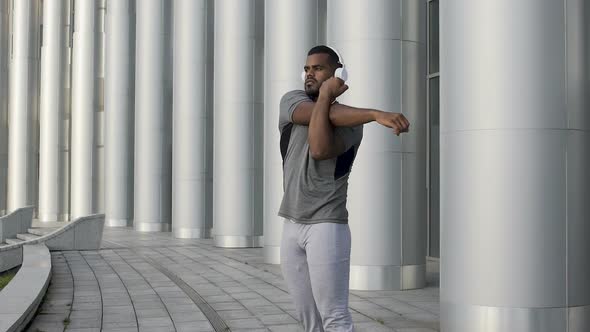 Strong handsome male in sportswear flexing muscles before fitness training