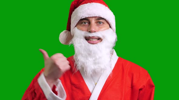 Santa Claus in Red Suit Pointing Aside on Green Chroma Key Background