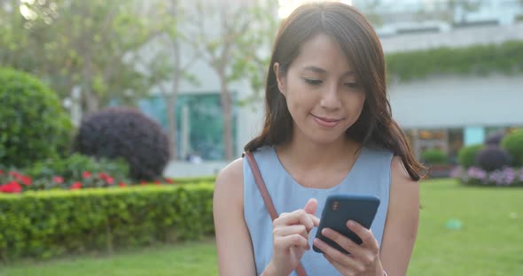 Woman look at the cellphone in park