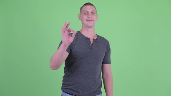 Portrait of Happy Young Man with Ok Sign
