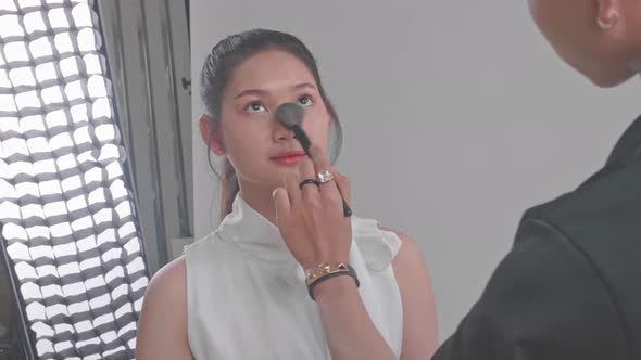 Backstage Of The Photo Shoot: Make-Up Artist Applies Makeup On Beautiful Asian Model