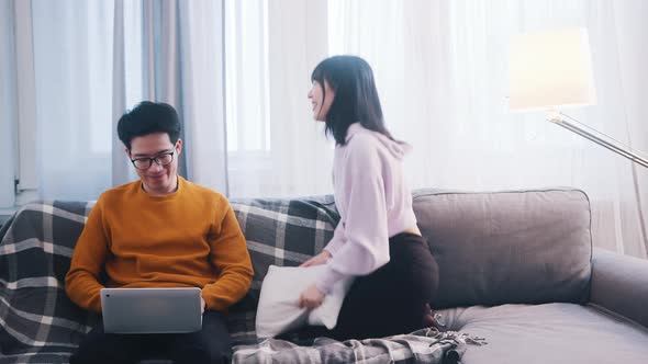 Young Woman Seeking Attention of Her Boyfriend Who is Working on Laptop