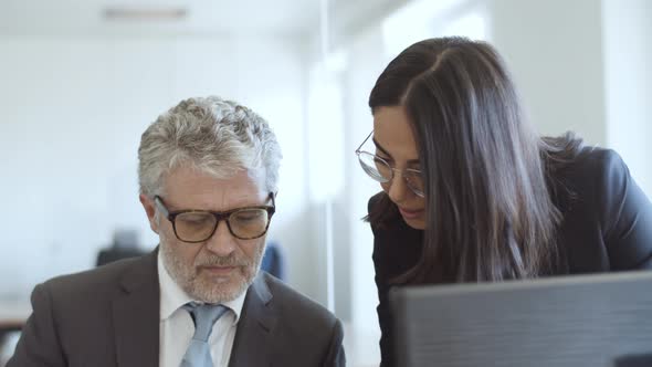 Focused Positive Female Assistant Explaining Document Details