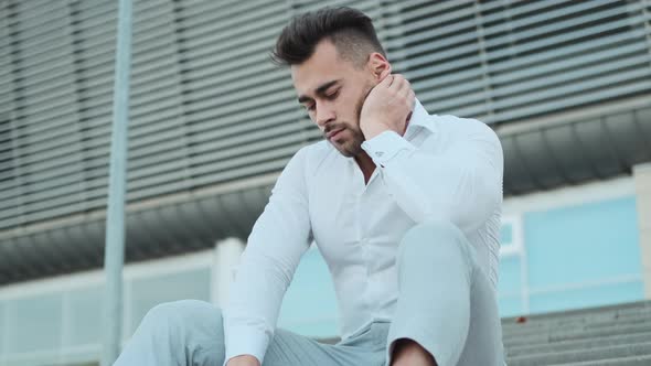 Young Man Sitting On The Stairs Of The Building.