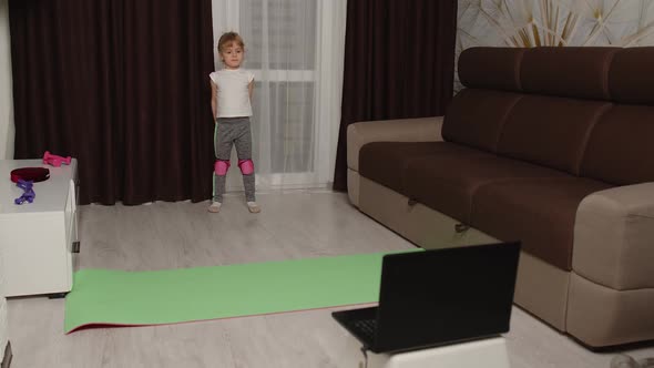 Kid Girl Doing Sport Exercises Watching Video Online Education Lessons on Laptop Computer at Home