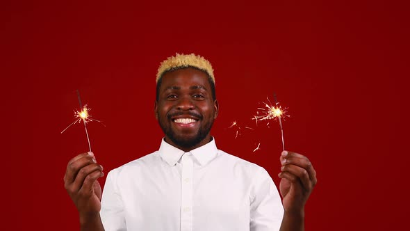 African American Man Holding a Burning Stick of Dynamite in Studio Red Background