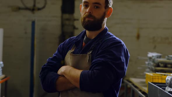 Metalsmith standing with arms crossed in workshop 4k