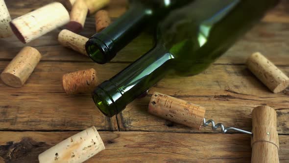 Wine bottles on an old vintage wooden board and falling corks. Slow motion.