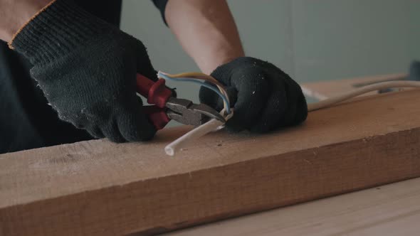 Hands in Black Gloves Cut the Wires with Wire Cutters