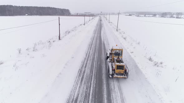 Aerial view of Snowblower Grader is driving on a winter snowy road 08