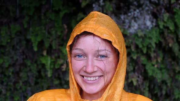 Portrait of a Woman in a Yellow Rain Coat Looks and Smiles
