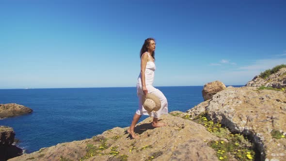 The Girl Goes Up the Cliff Barefoot Against the Blue Sea