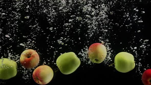 Ripe Fruits Green and Red Apples Falling Into Water Black Background