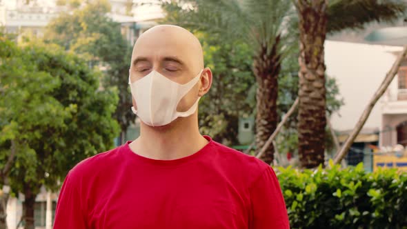 Closeup of an Adult Man Wearing a Medical Mask Looking Around and Looking at the Camera on an Empty