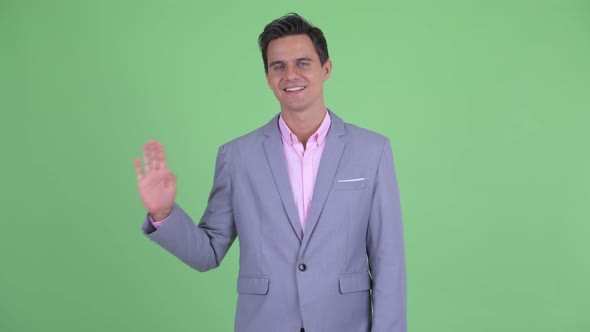 Happy Young Handsome Businessman Waving Hand