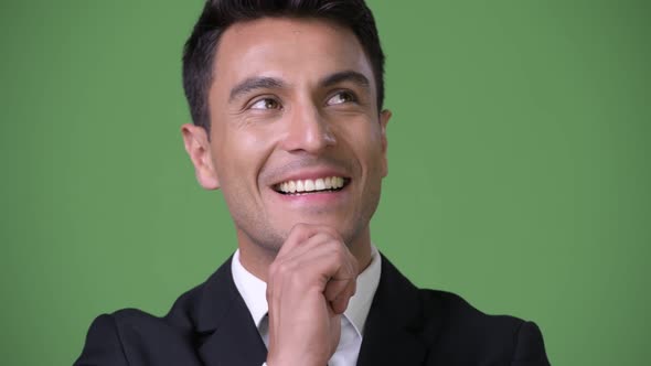 Young Handsome Hispanic Businessman Against Green Background