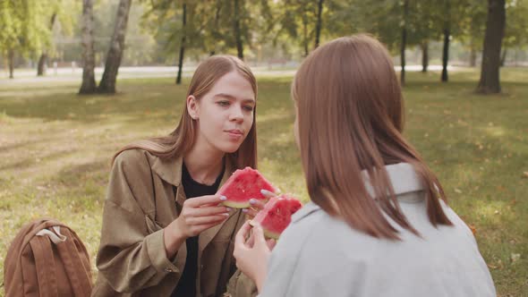 Cheerful Girls Enjoying Watermelon in Park