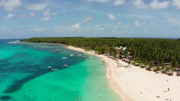 Tropical Daco Island with a Sandy Beach and Tourists.