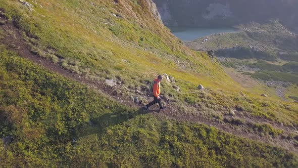 Tourist Hiker with a Backpack Running on Mountain Path in Carpathian Mountains