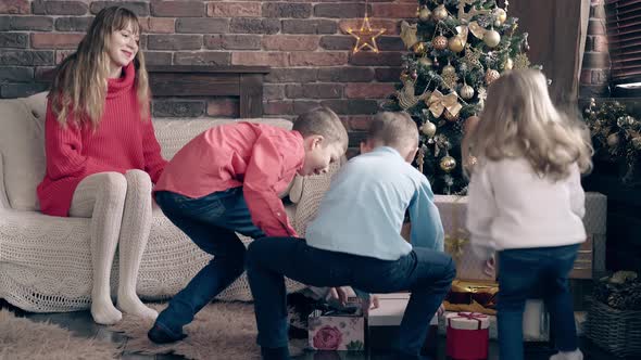 Kids Run Up To Christmas Presents Near Decorated Tree