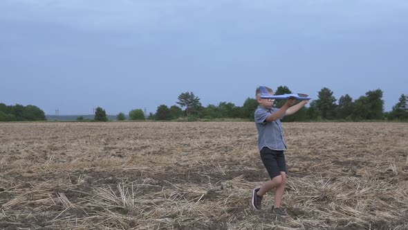 Happy guy with a toy airplane on a wheat field in the sunset light.