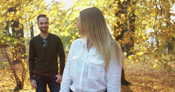 Happy Girl Turns Back to Her Lovely Man and They Smile in Autumn Park