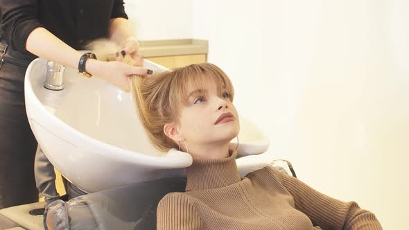 Young Woman Dyeing Hair in Beauty Saloon