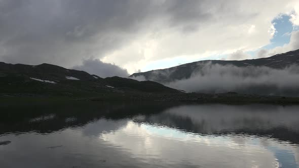 Mountain Lake Above the Clouds in Overcast Dark Weather