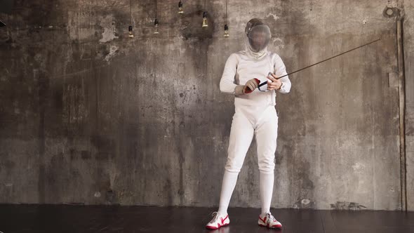 Fencer Is Checking and Bending His Epee and Moving It in Air in a Training Hall