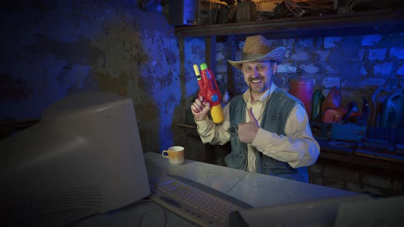 A cowboy in a straw hat near the computer raises his thumbs up