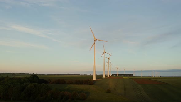 Horizontal Panning From a Drone View of a Massive Wind Farm Among Green Fields